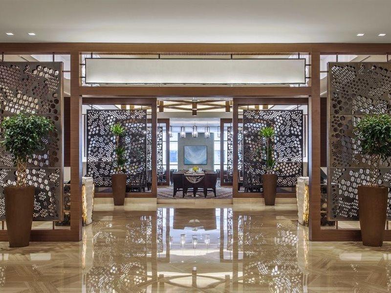 Jabal Omar Hyatt Regency Makkah Hotel Mecca Exterior foto The photo showcases a modern, elegant interior space, likely within a hotel or upscale establishment. It features decorative screens made of intricate patterns that serve as partitions. The floor is polished marble, reflecting the bright lighting abo