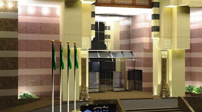 Jabal Omar Hyatt Regency Makkah Hotel Mecca Exterior foto The photo shows a building entrance decorated in a luxurious style. It features a prominent glass entrance with a modern design. In front of the entrance, there are several vertical flags, which appear to represent Saudi Arabia. The architecture incl