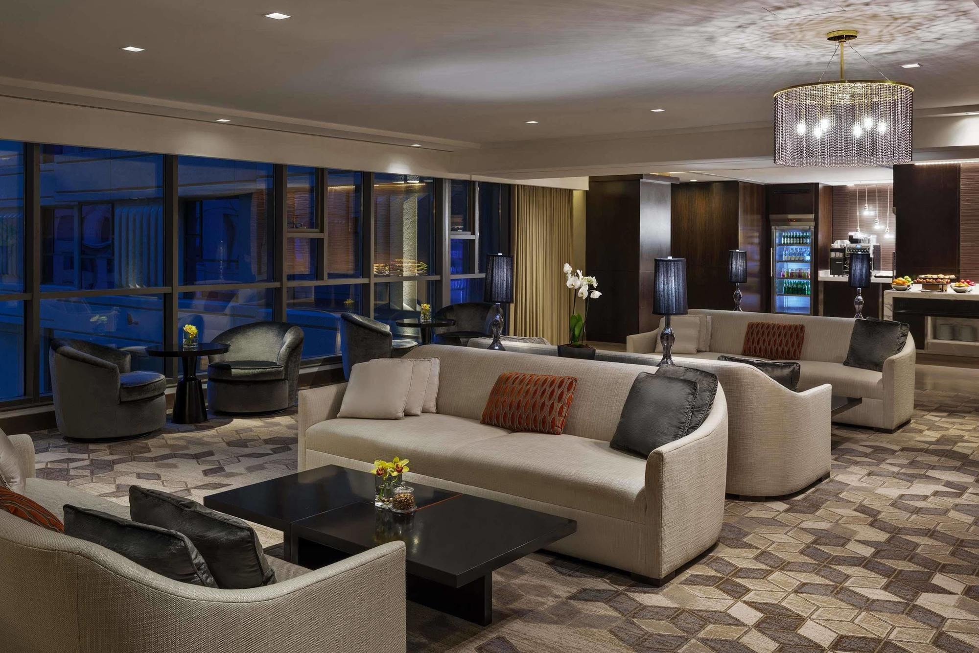 Jabal Omar Hyatt Regency Makkah Hotel Mecca Exterior foto The photo shows a modern and elegant lounge area. It features comfortable cream-colored sofas arranged in a cozy setting, along with dark coffee tables. The space is illuminated by warm lighting, including a stylish chandelier. Large windows allow fo